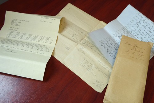 Photograph taken from above of an array of documents on a wooden table.