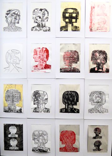 A series of art prints of 'heads' in profile.