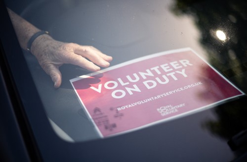Volunteer on duty sign in the front window of a car